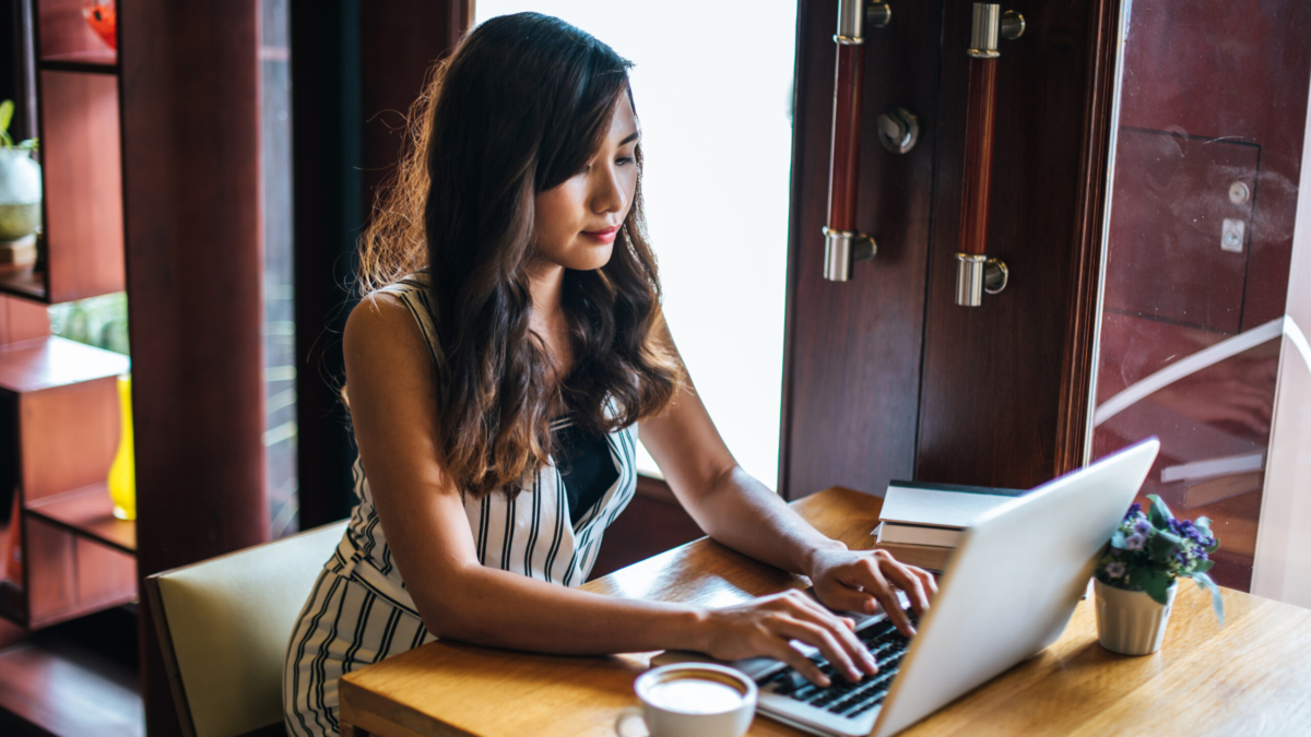 Beautiful woman working with laptop computer at coffee shop cafe