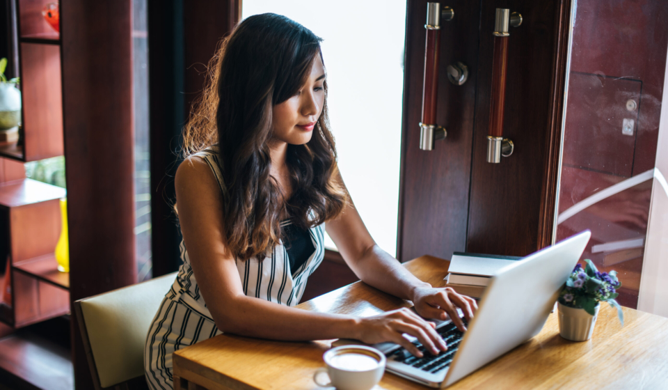 Beautiful woman working with laptop computer at coffee shop cafe