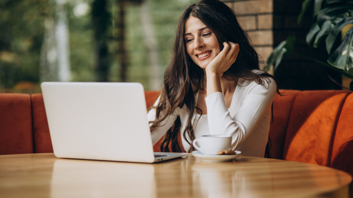 Young beautiful business woman working on cimputer in a cafe